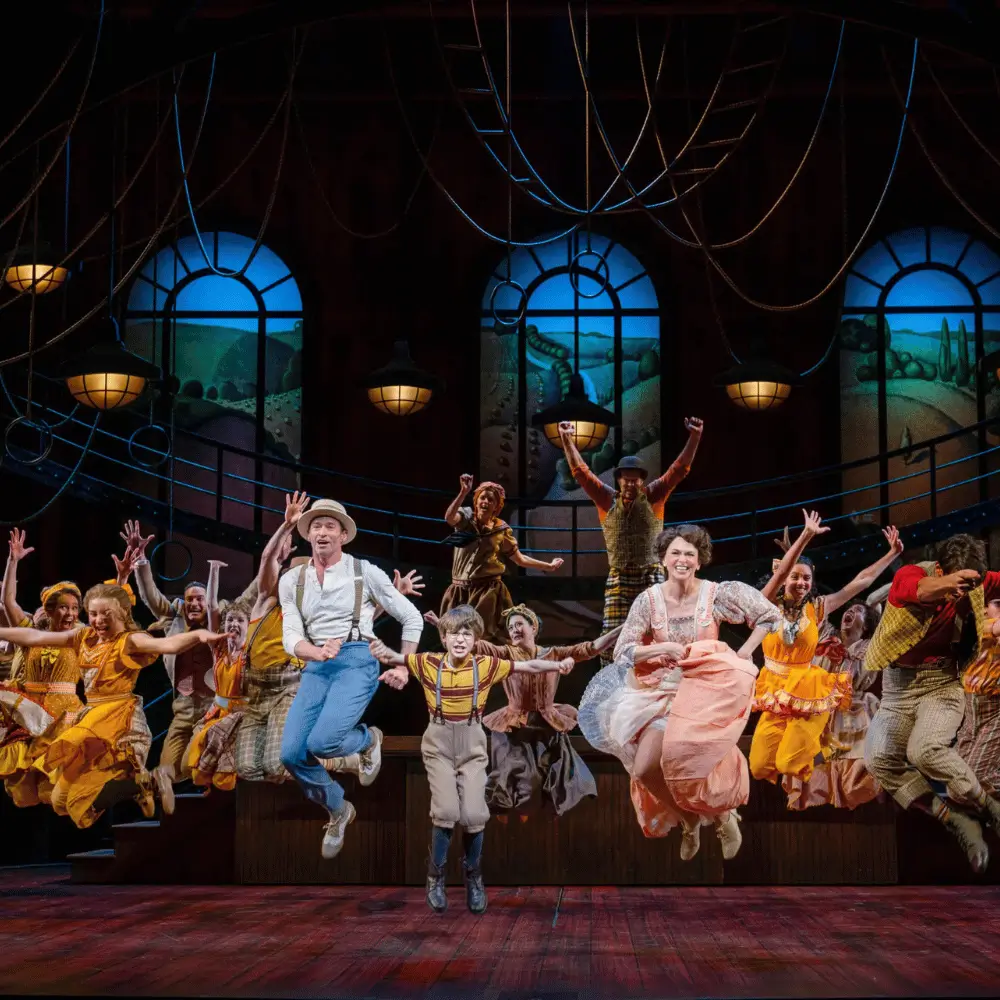 A musical ensemble in period costume leaping mid-air in unison during a dance number
